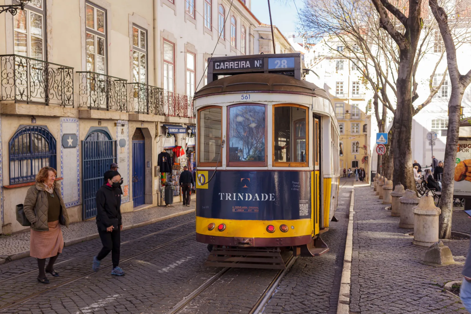 yellow Tram 28 on a narrow Alfama street