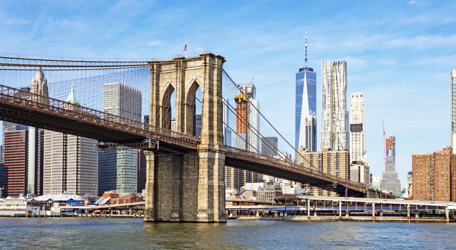 kids at the Brooklyn Bridge with the Manhattan skyline behind